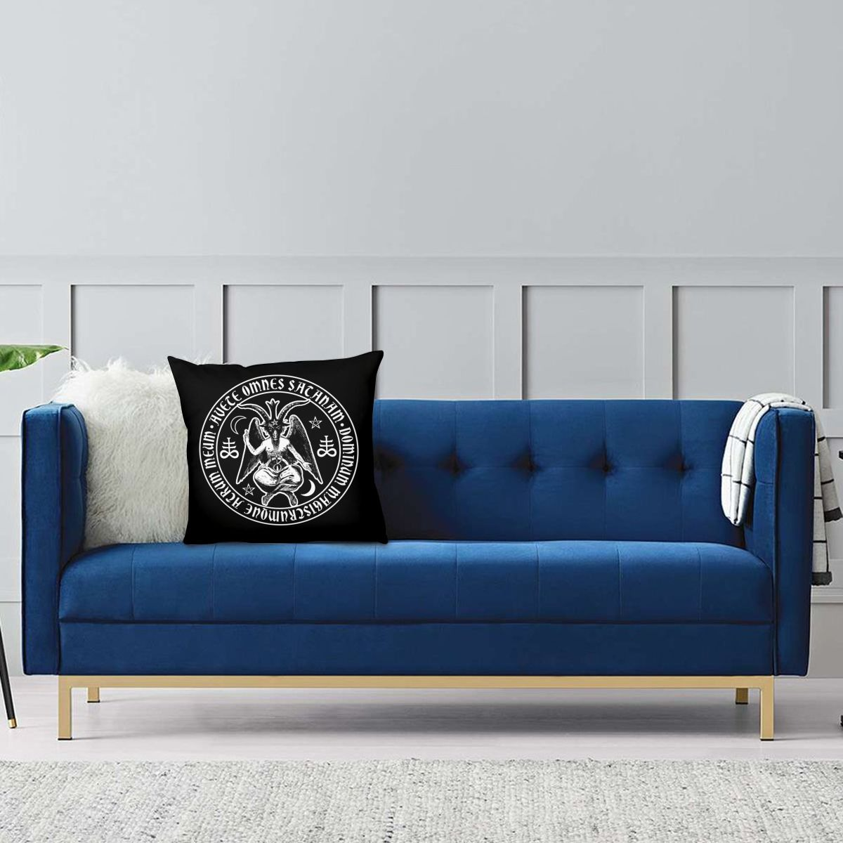 Decorative pillow cover with satanic goat print on a blue sofa in a stylish gothic living room.