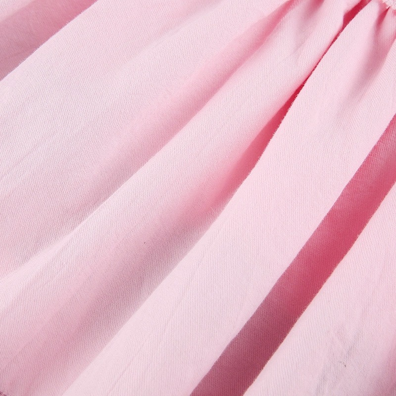 Close-up of pink double layer pleated skirt fabric with soft texture and delicate draping.