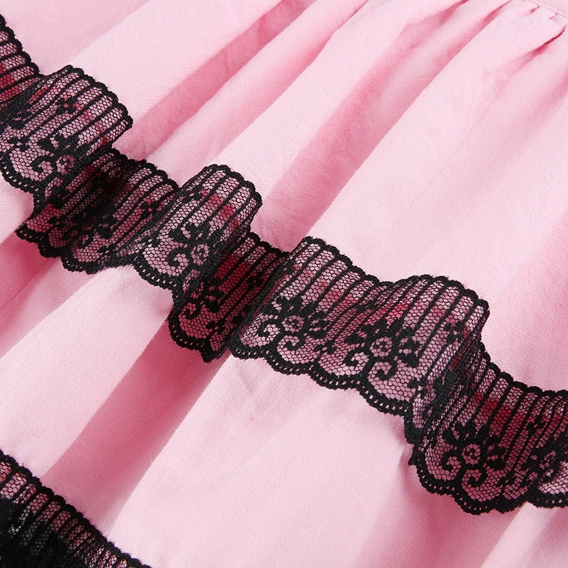 Close-up of a pink pleated skirt with black lace trim, showcasing stylish punk fashion details.