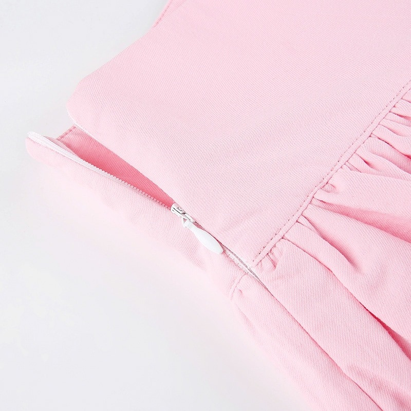 Close-up of the zipper on a pink women's double layer pleated skirt with black lace detailing.