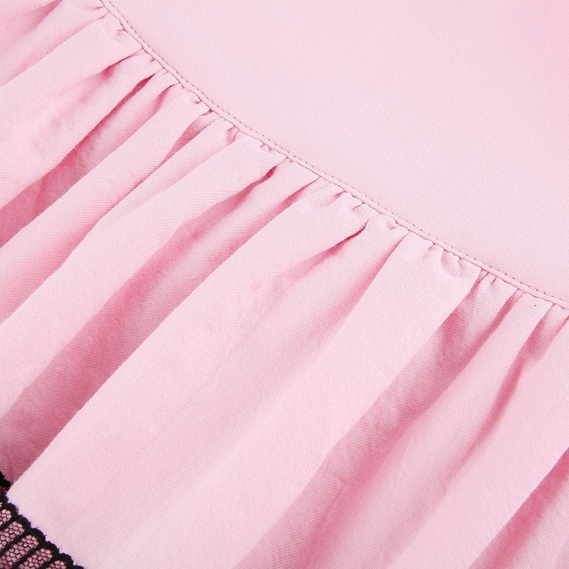 Close-up of pink double layer pleated skirt with elegant black lace trim for a stylish punk look.