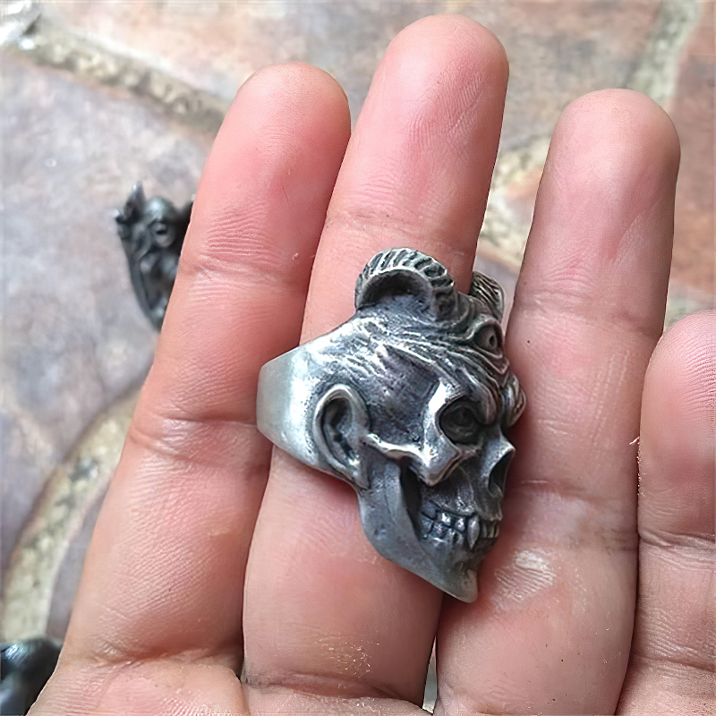 Three-eyed devil skull ring in stainless steel held in hand, perfect for goth and biker fashion styles.