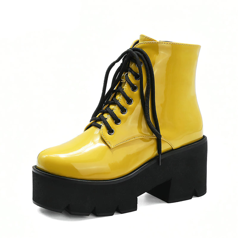 Stylish yellow platform ankle boots with round toe, lace-up closure, and thick black square heel for winter fashion.