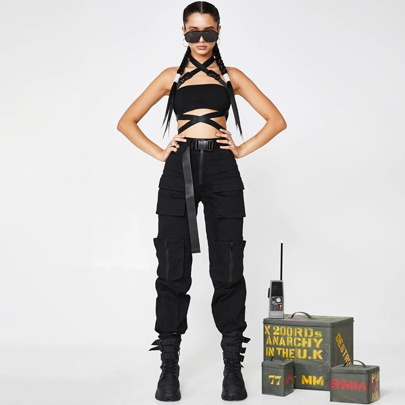 Fashionable woman in black cargo pants and crop top, showcasing edgy autumn style with stylish braids and accessories.