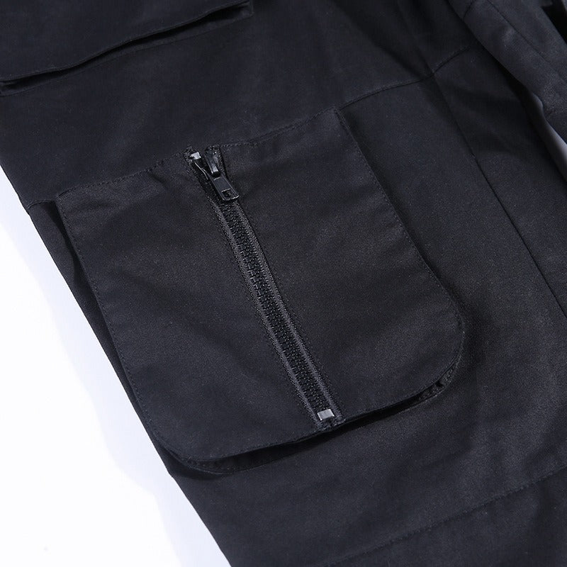 Close-up of pocket with fake zipper on pleated gothic pants for women, featuring stylish black fabric.