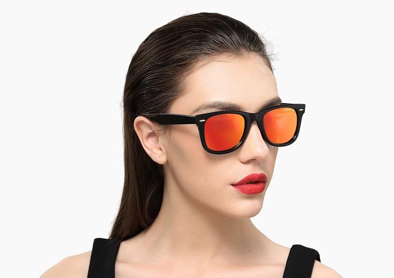 Woman wearing classic retro polarized sunglasses with mirrored orange lenses for UV protection.