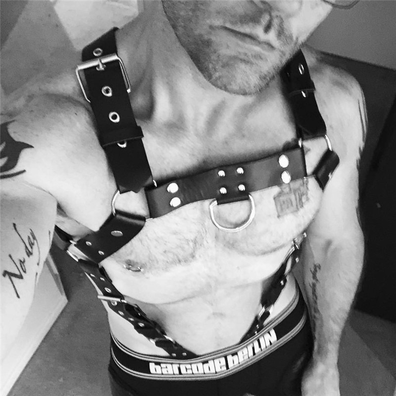 PU leather body bondage harness with metal rivets and adjustable suspenders for alternative fashion style.