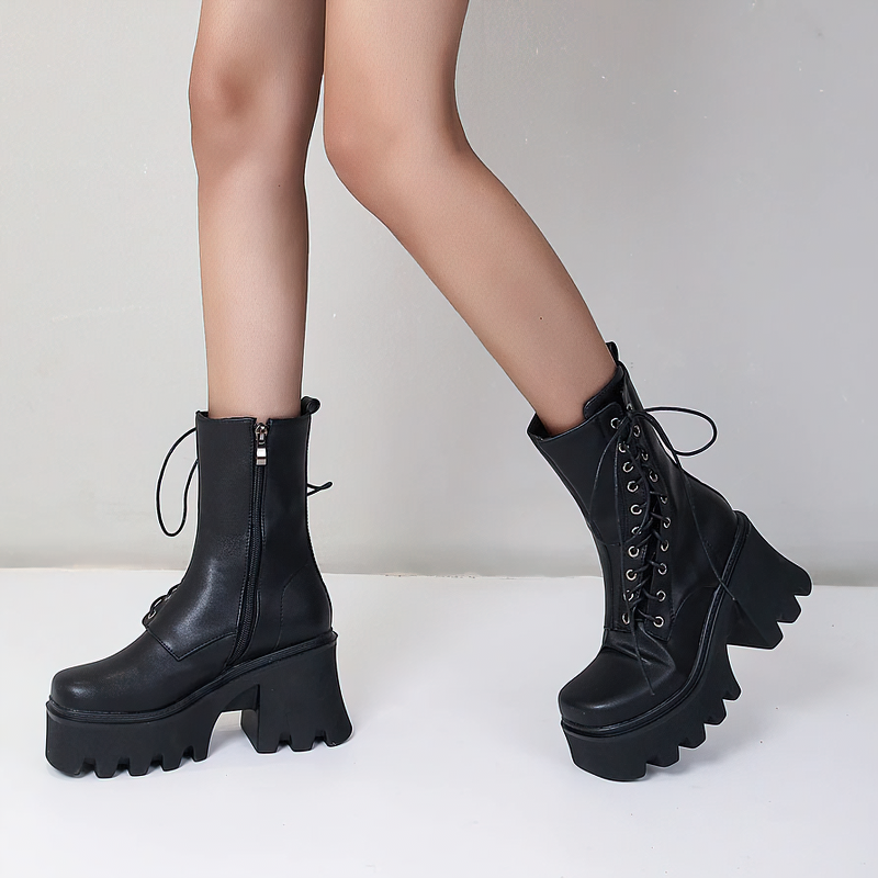 Trendy women's black PU leather lace-up boots with high tractor soles for a chic gothic look.