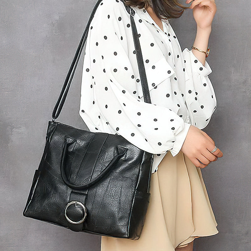 Black pu leather women's retro handbag, featuring ring decoration and a stylish shoulder strap for travel or everyday use.