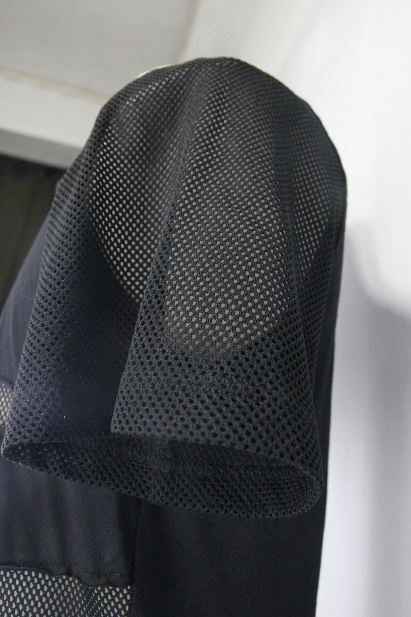 Close-up of black mesh hood detail on a punk-style men's t-shirt, showcasing trendy transparency and unique design.