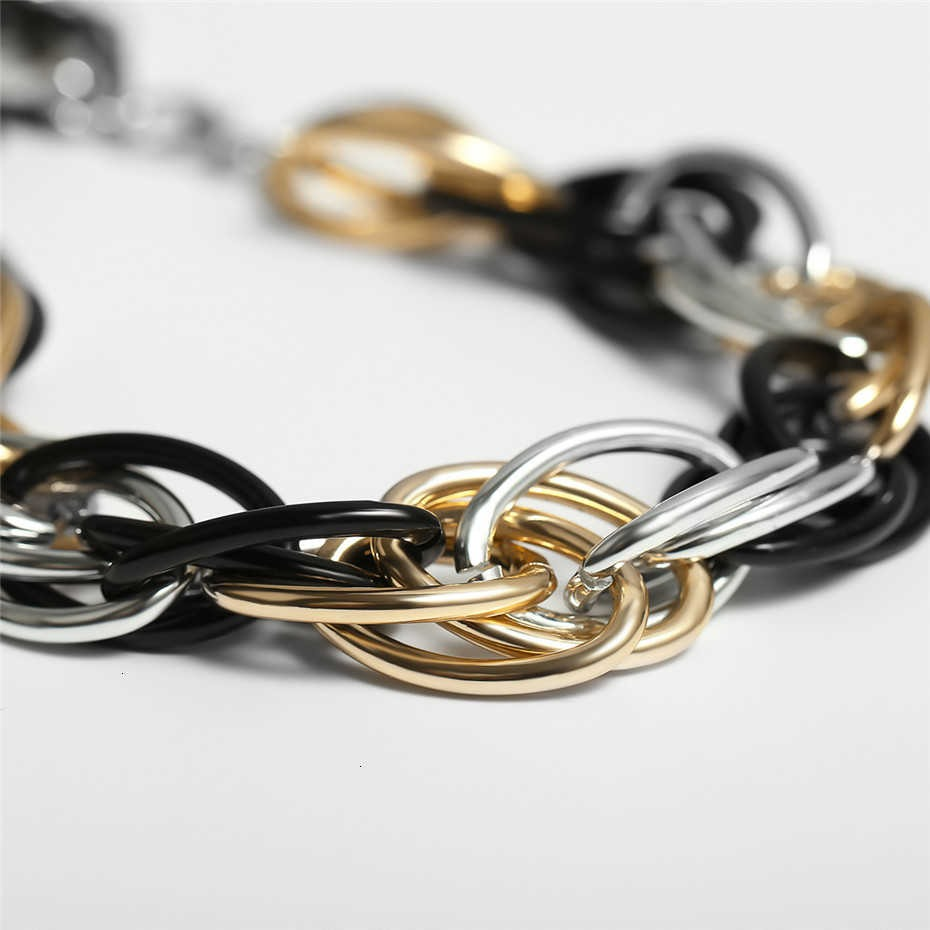 Close-up of a punk curb Cuban twisted necklace in gold, silver, and black colors, featuring a massive chain design.
