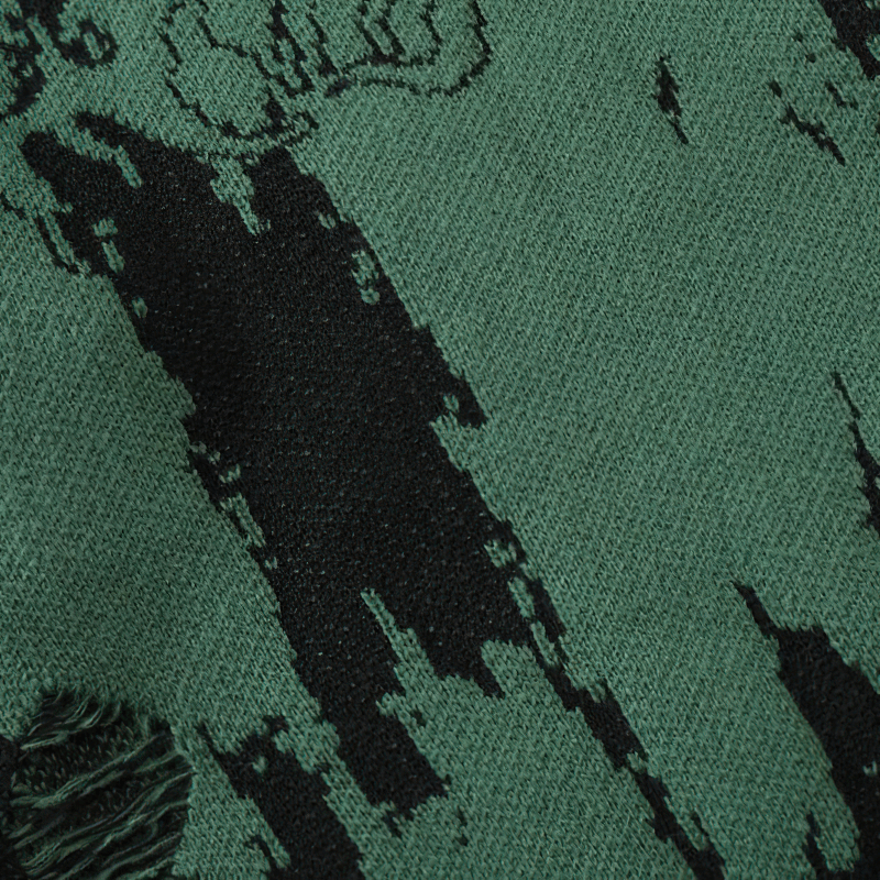 Close-up of a punk gothic knitted sweater with a green and black ripped texture, ideal for grunge fashion.