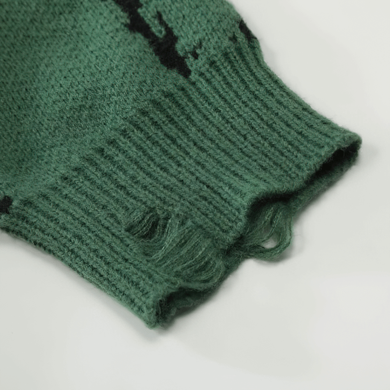 Close-up of a green knitted sweater sleeve featuring a ripped design and textured fabric for a punk style.