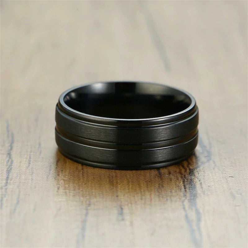 Punk matte black stainless steel ring with groove, perfect for men's jewelry and rave outfits, showcased on a wooden surface.