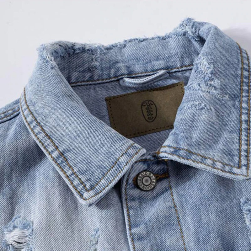 Close-up of a punk men ripped denim vest collar, featuring frayed edges and stylish distressed detailing.