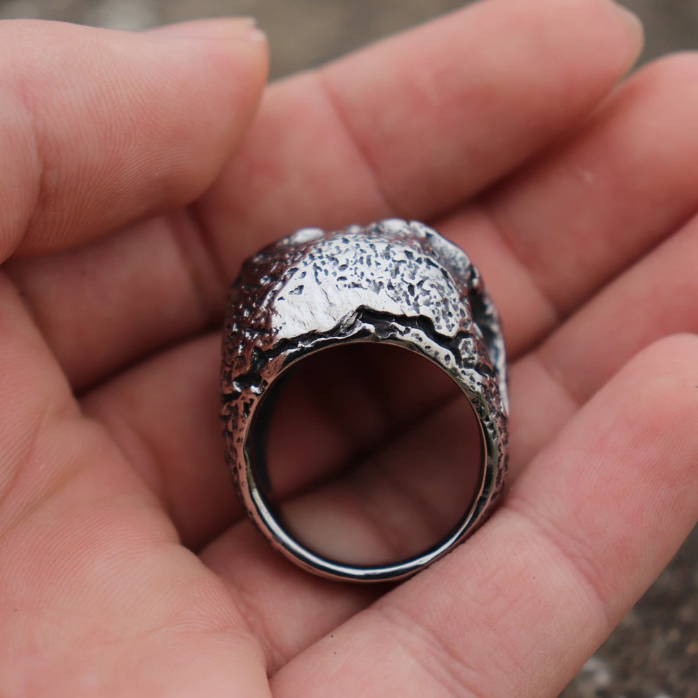 Punk men's ring featuring a rugged skull design, crafted from solid 316L stainless steel, held in a hand.