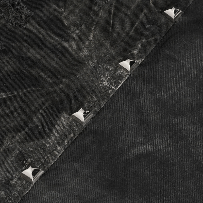 Close-up of punk rock asymmetrical vest showing gothic mesh rivets and distressed fabric details.