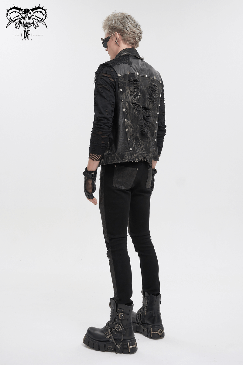 Edgy punk rock model wearing a distressed asymmetrical waistcoat with gothic mesh rivets and stylish black pants.