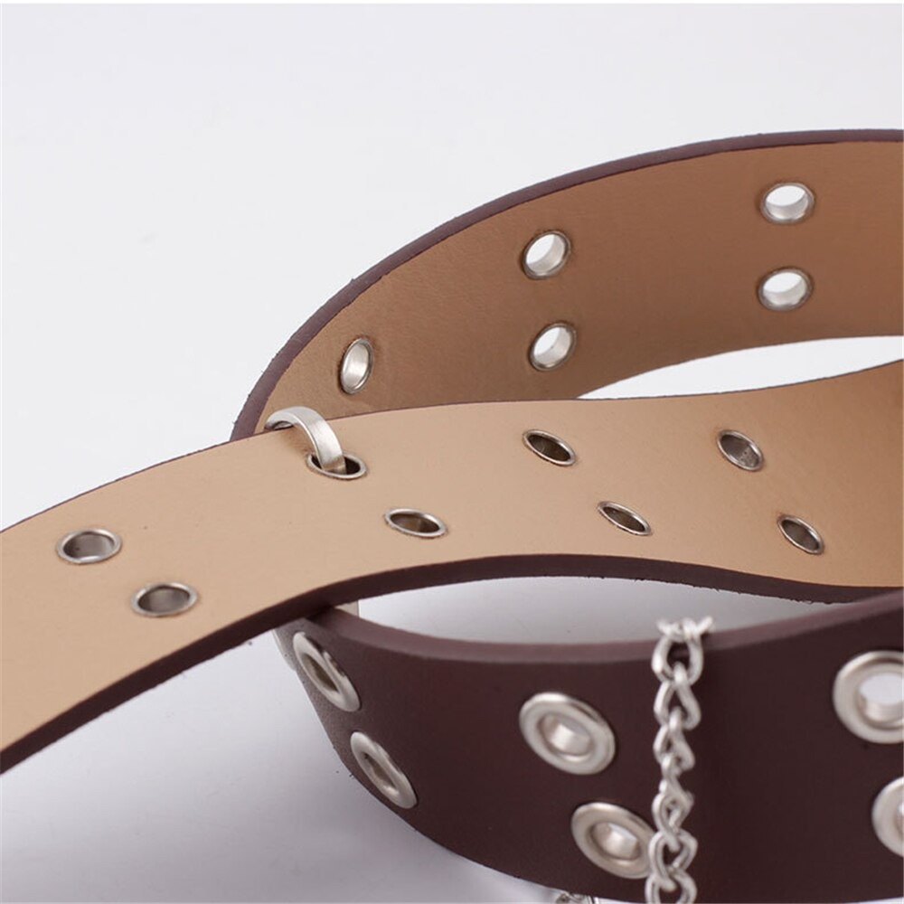 Close-up of punk rock PU leather belt in brown with silver grommets and chain accessory, perfect for stylish women's outfits.