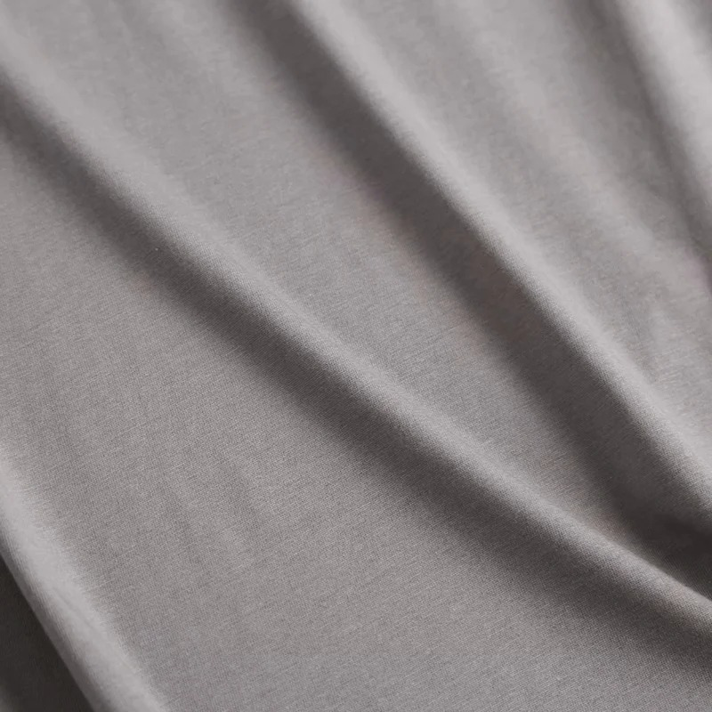 Close-up of soft grey fabric for punk rock women's cotton T-shirt, showcasing casual style and pleasant texture.