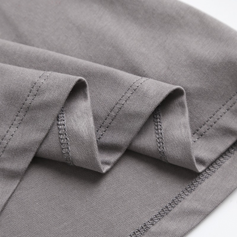 Close-up of the grey fabric showing the soft texture and stitching of a women's cotton t-shirt.