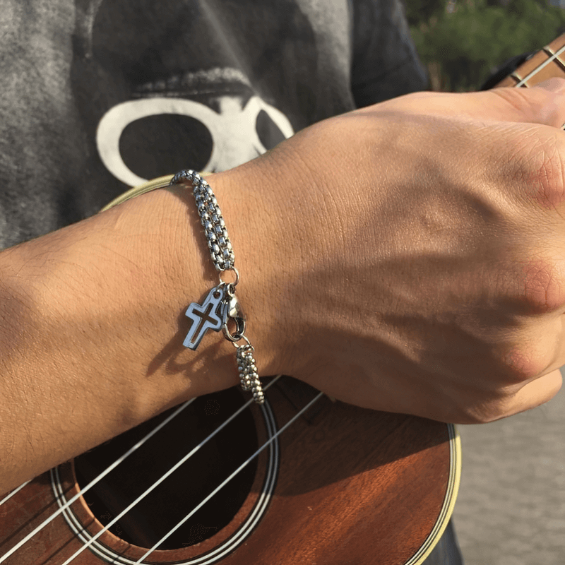 Stylish titanium steel double chain bracelet with cross pendant worn on a hand, perfect for biker outfits.