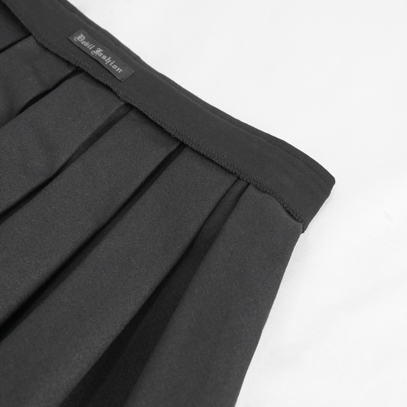 Close-up of black pleated skirt waistband with brand logo, showcasing punk fashion details.