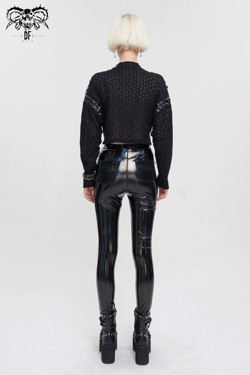 Back view of a woman in a black punk long sleeve short top and glossy high-waisted pants, showcasing alternative fashion.