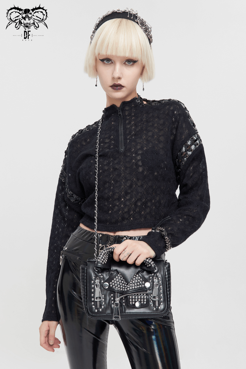 Gothic women's black long sleeve short top with punk stitch detailing, paired with a stylish studded handbag.
