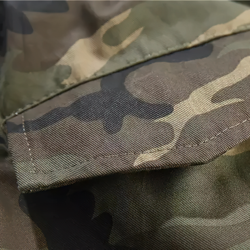 Close-up of camouflage fabric on punk style cargo pants with detailed stitching and pocket.