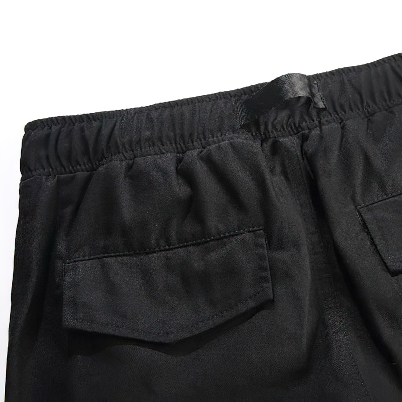 Close-up of black punk style cargo pants featuring spacious back pockets and an elastic waistband.