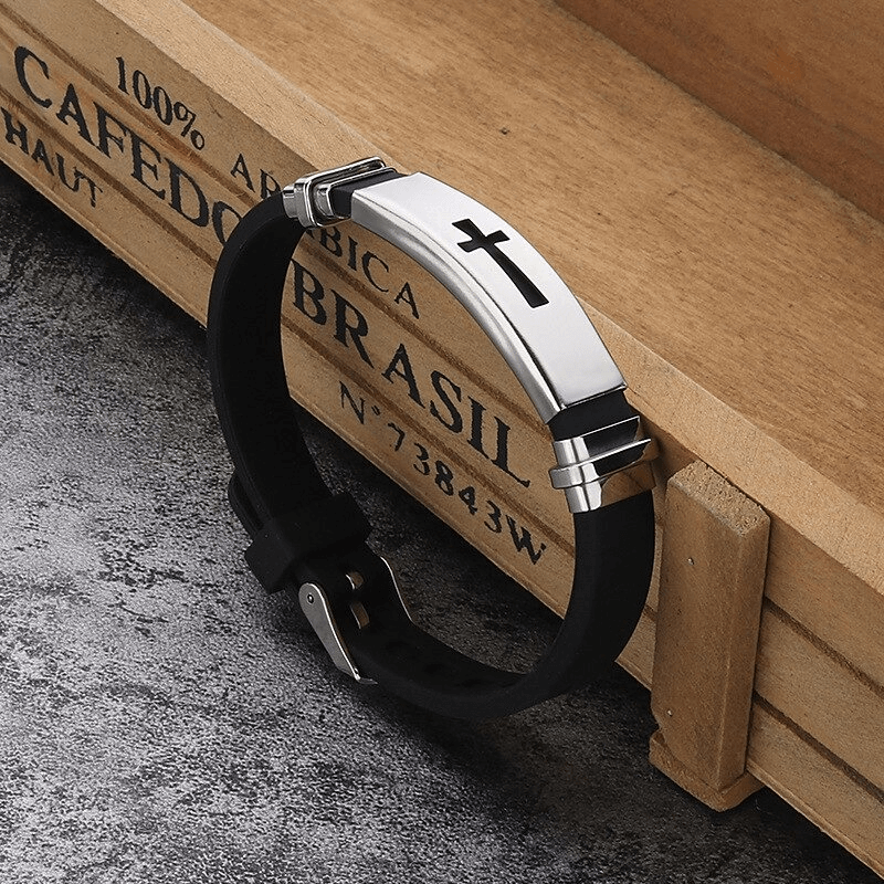 Stylish punk-style cross bracelet in titanium steel and silicone on wooden background.