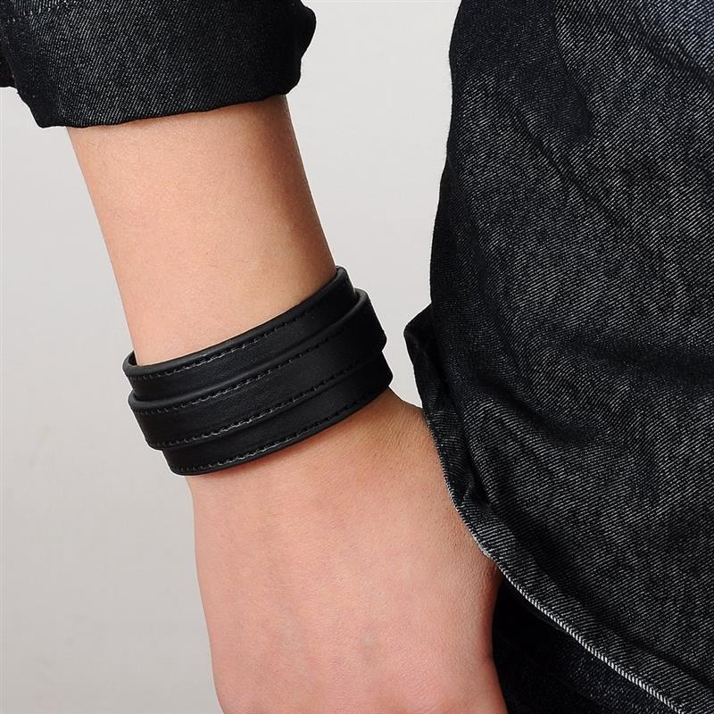 Black punk-style genuine leather wristband on wrist, perfect for casual and rock outfits.