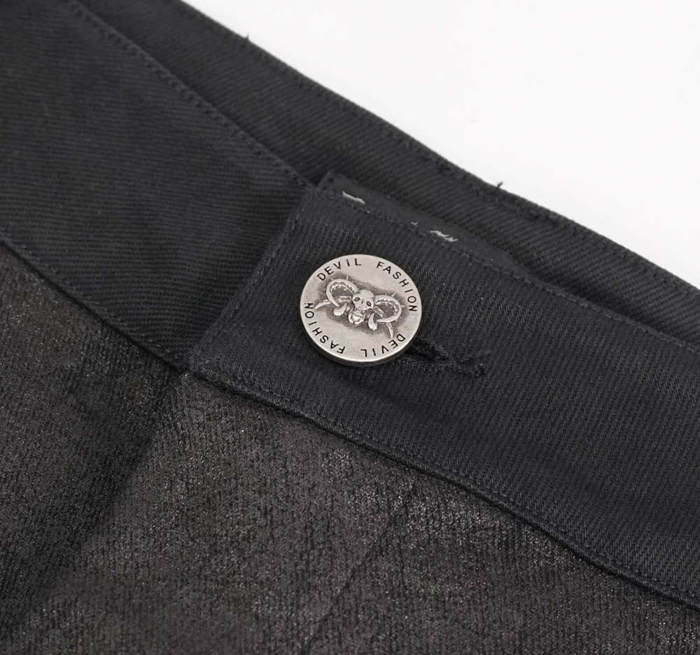 Close-up of the waistband and metal logo button on punk style men's black jeans.