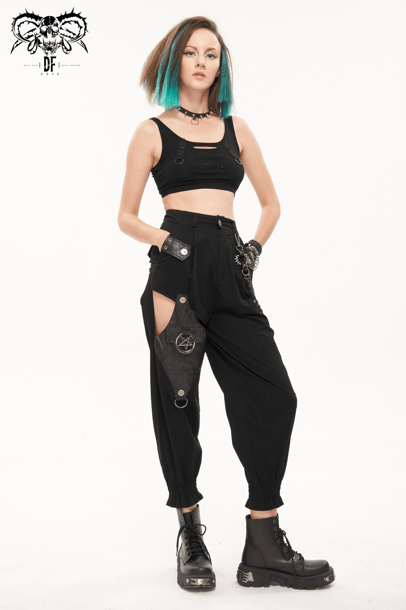 Trendy punk style woman in black asymmetrical cargo pants with detachable chain and crop top, showcasing a bold fashion statement.