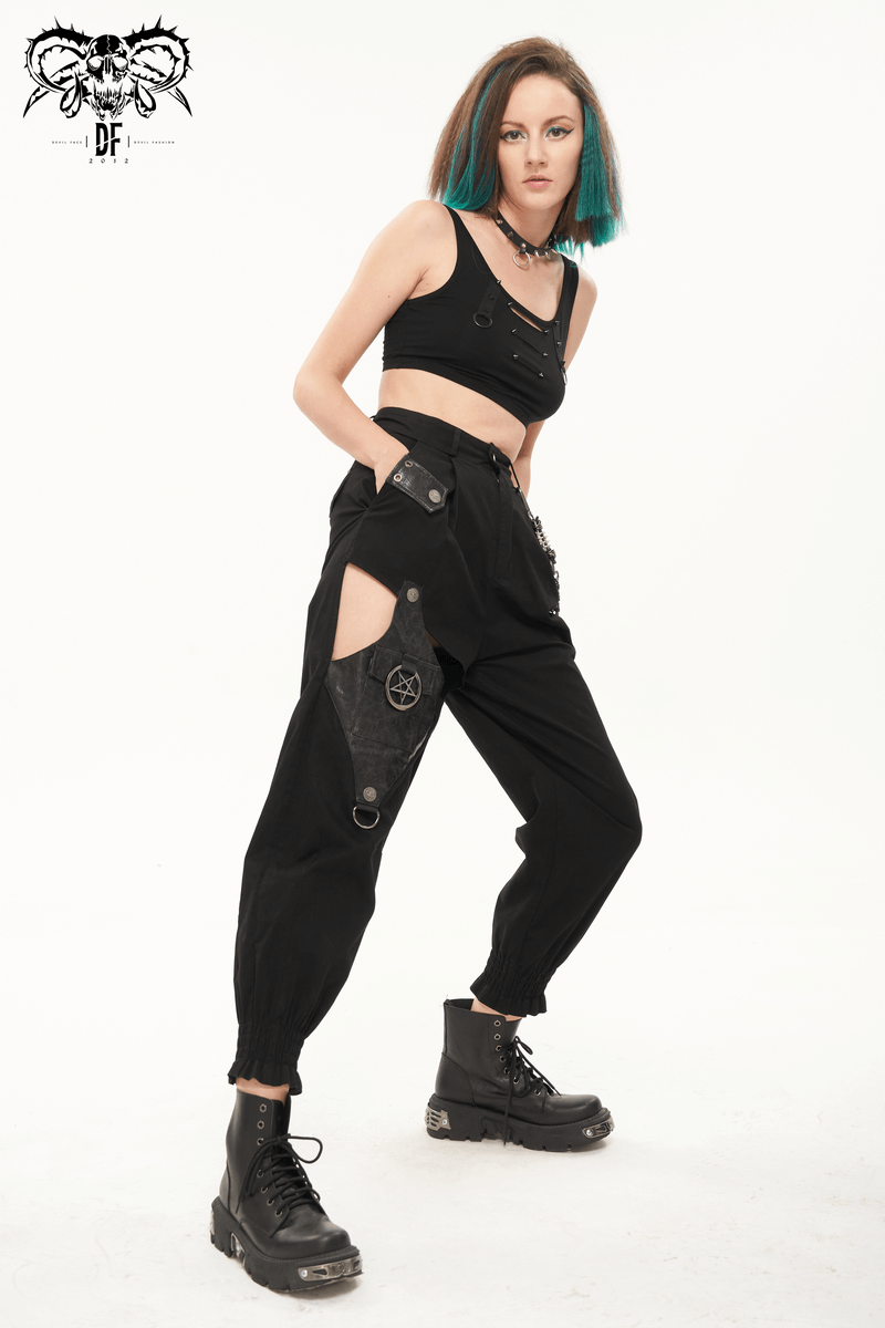 Trendy punk style women's black asymmetrical cargo pants with detachable chain and stylish crop top, modeled with edgy boots.
