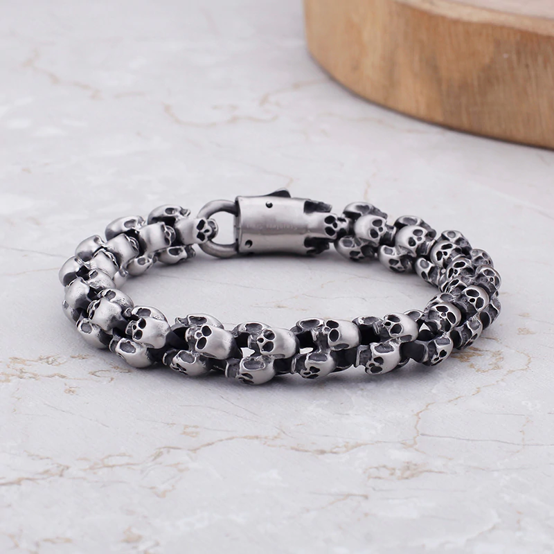 Punk style stainless steel skull bracelet for men, featuring a unique design of interlocking skulls.