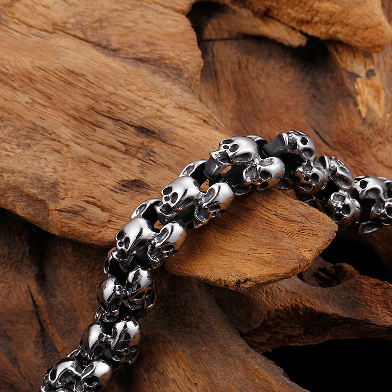 Punk style stainless steel skull bracelet resting on natural wood, showcasing its unique and edgy design.