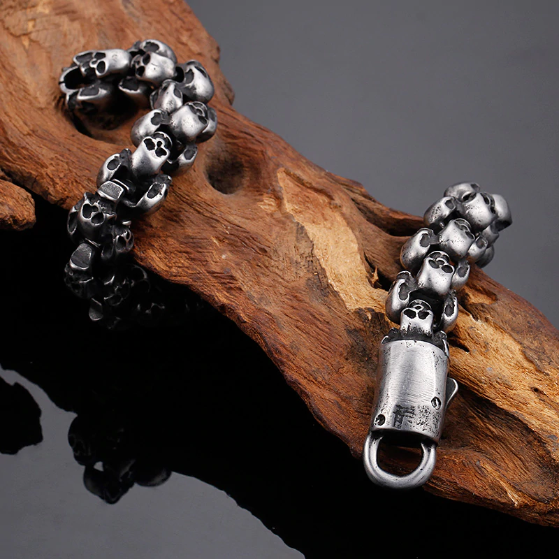 Punk style stainless steel skull bracelet on wooden surface, perfect accessory for men's edgy outfits.