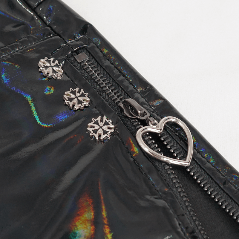 Close-up of punk women's black faux leather shorts showing zipper detail and decorative studs.