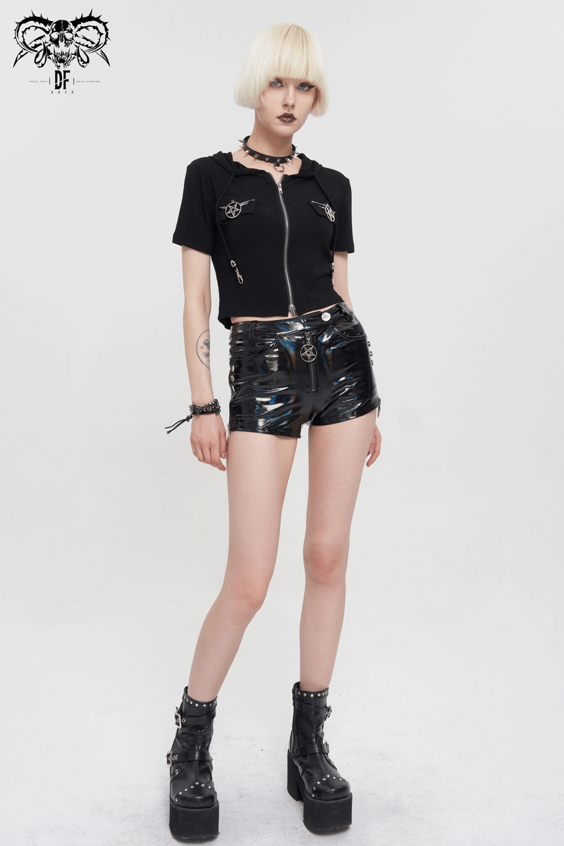 Model showcasing punk style black faux leather shorts with pentagram details and a black zippered top.