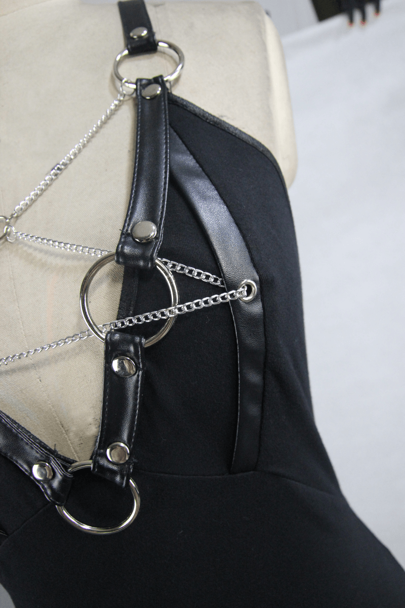 Close-up of women's black elastic camisole featuring silver chains and rings in punk fashion style.
