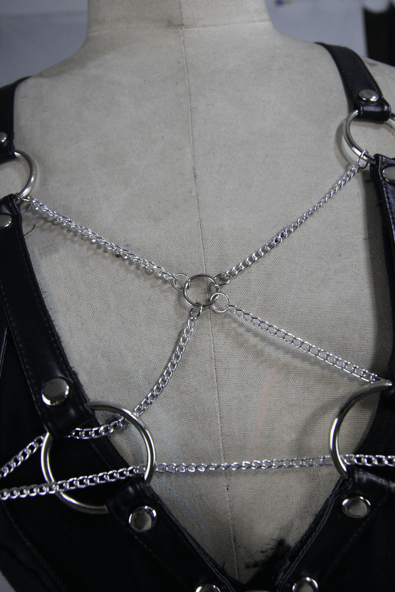 Back detail of a punk women's black camisole featuring silver chains and rings for a trendy edgy look.