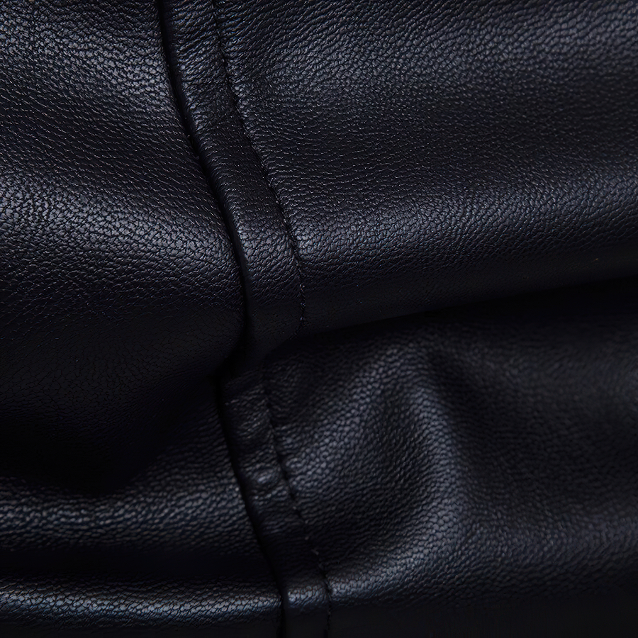 Close-up of black PU leather, showcasing its texture and stitching, perfect for a punk-style men's jacket.