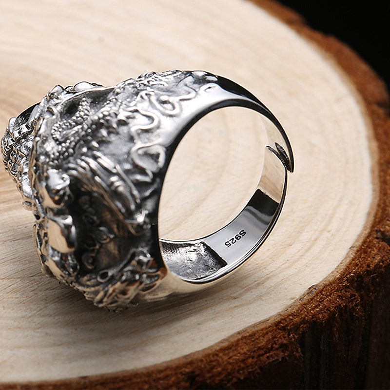 Close-up of a detailed silver skull ring on a wooden surface, showcasing intricate skeleton design, perfect for bikers.