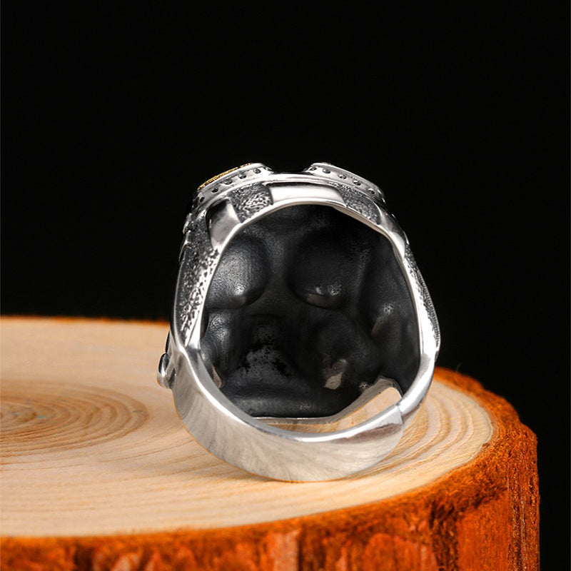 Detailed view of the 925 silver aviator skull adjustable ring, showcasing its unique design and weight on a wooden surface.