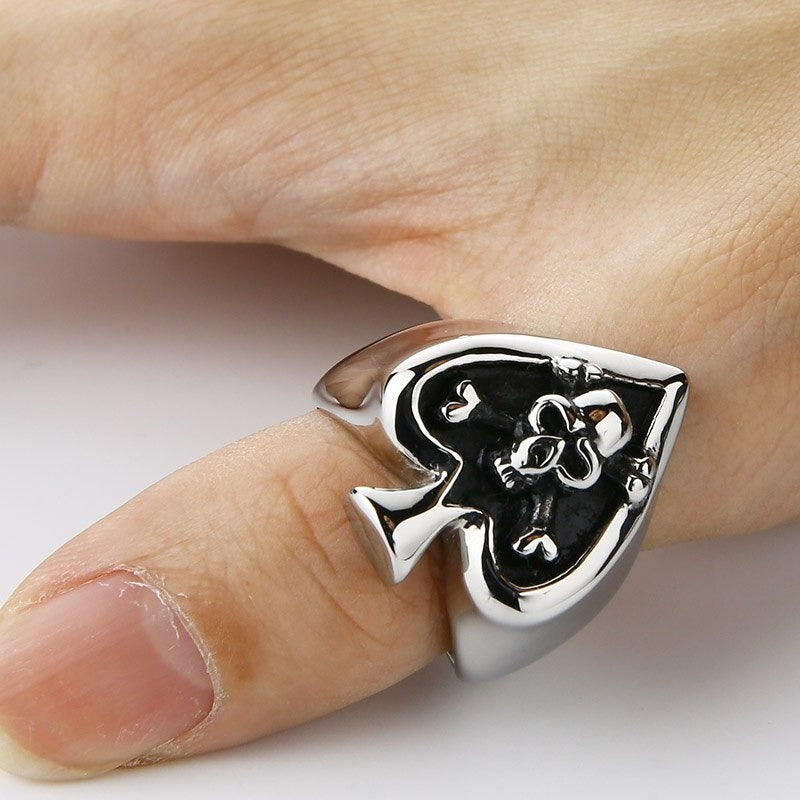 Retro card cross skull ring on a finger, showcasing unique rock style jewelry with a heart-shaped design.