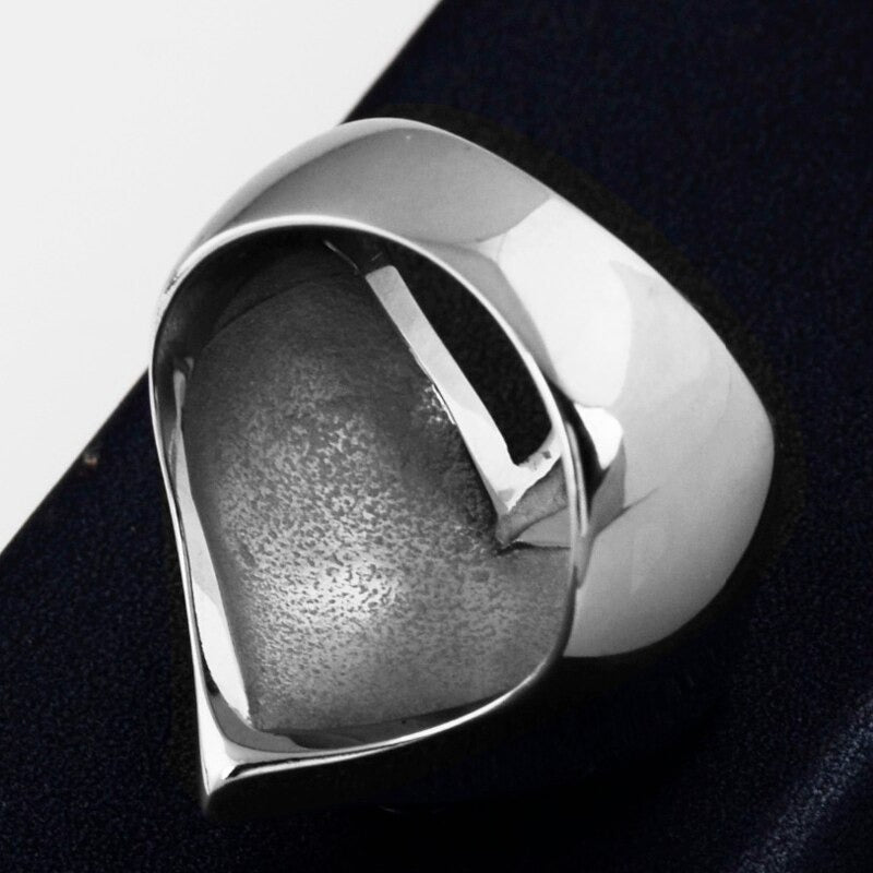 Shiny stainless steel heart-shaped skull cross ring on a dark background, perfect for rock style enthusiasts.