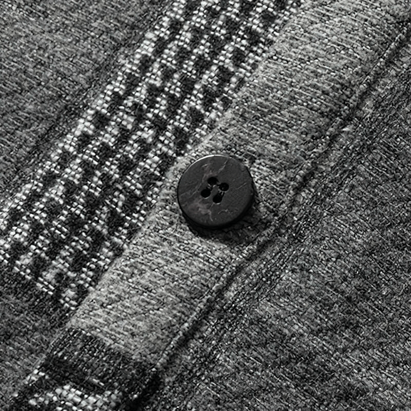 Close-up of a black button on a thick woolen plaid shirt, showcasing its cozy and stylish texture.