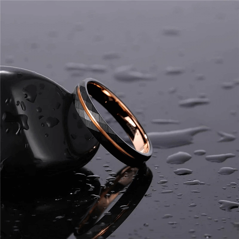 Unisex rhombus patterned tungsten steel band ring with black and rose gold accents on a wet surface.